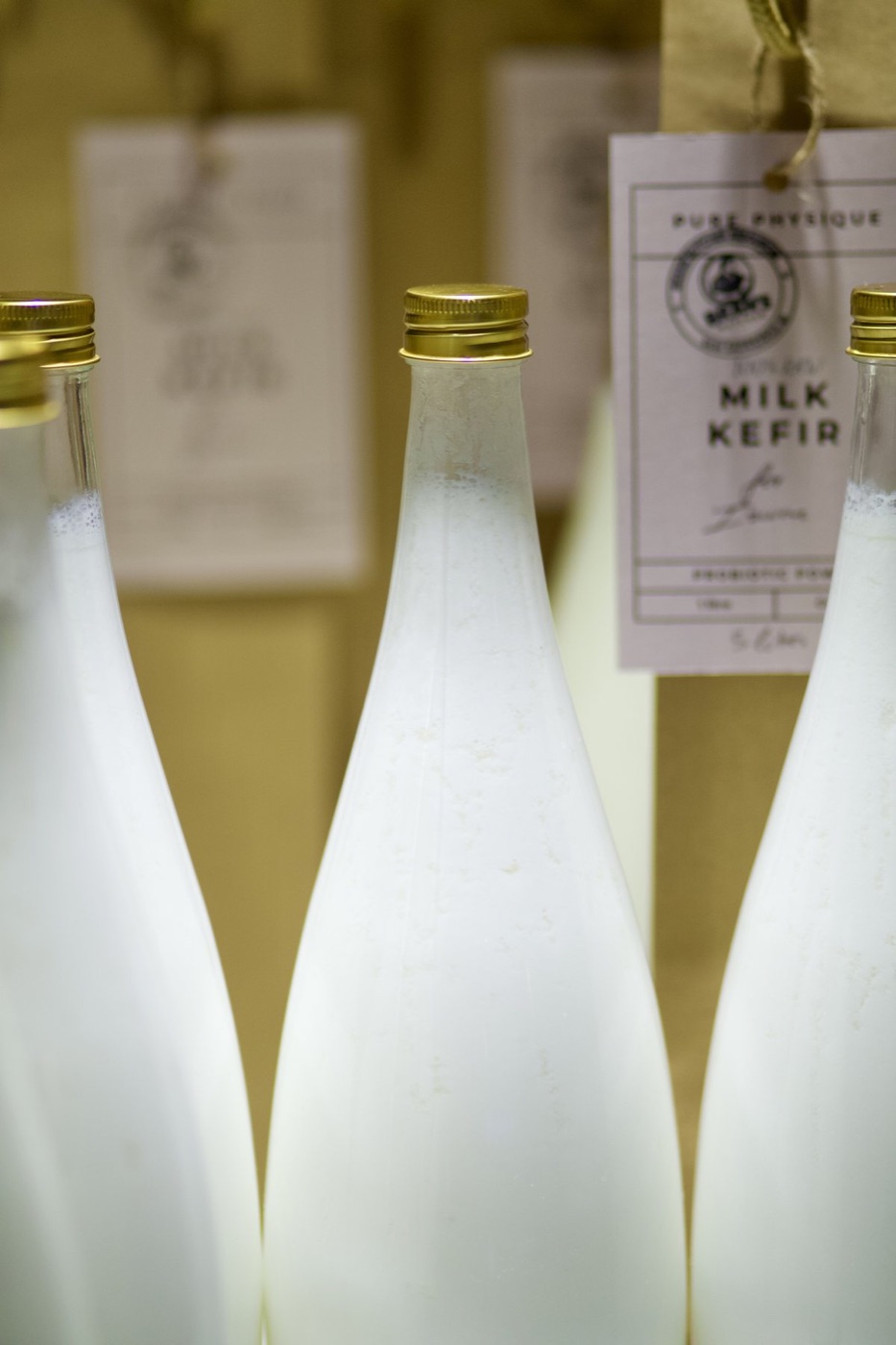 Bottles of Pure Physique milk kefir with kraft hang tags